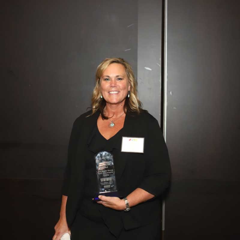 Liz Owens holding the Innovation in Business Award that TAG received in 2022